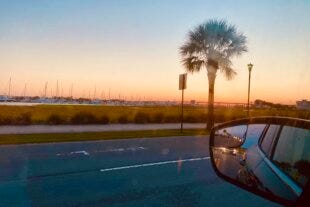 view of the beach at sunset from a car window