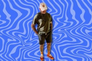 man wearing a t-shirt, shorts, tall orange socks and orange sneakers, set against a wavy blue background