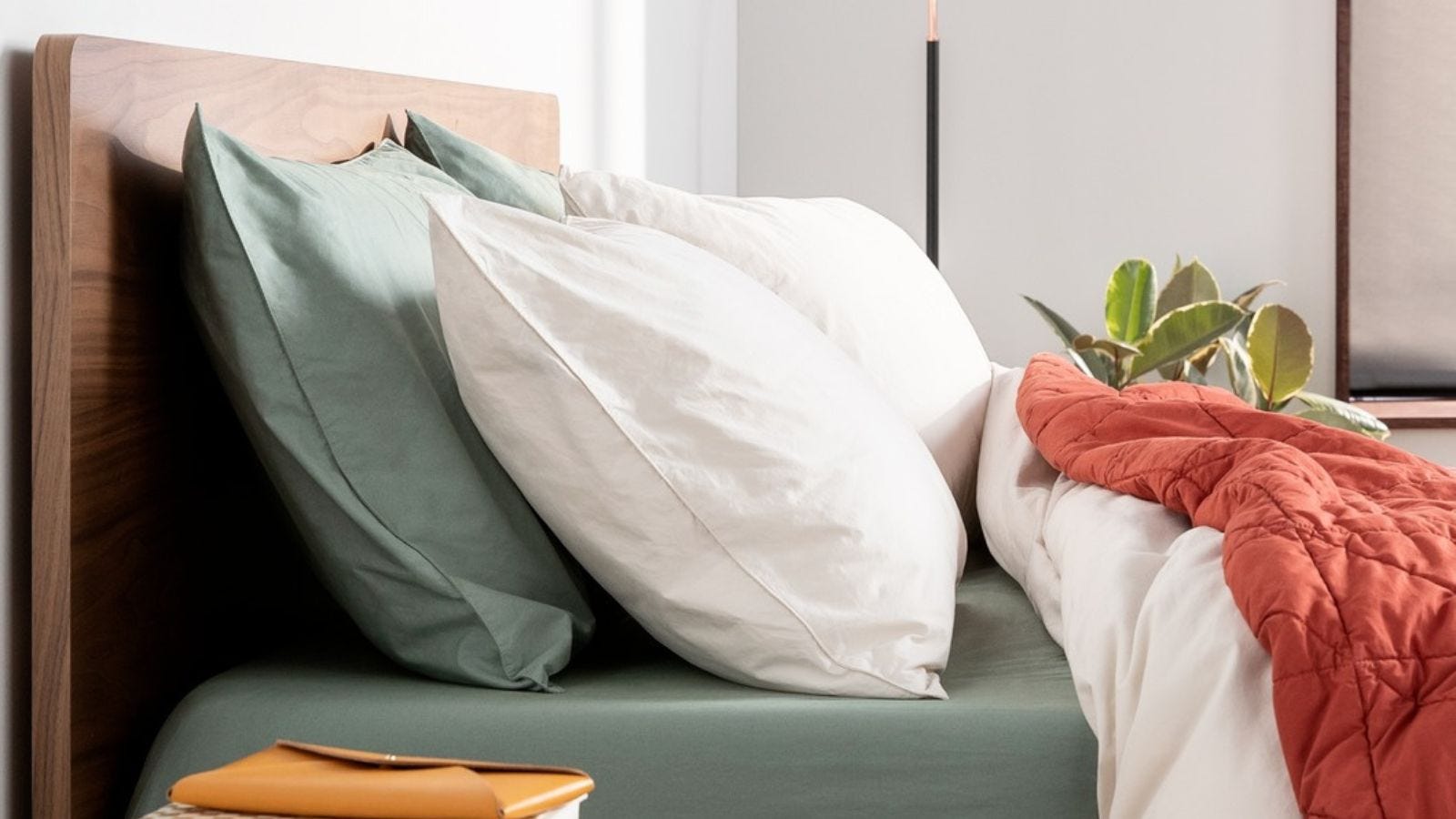 side view of a bed made up with fluffy pillows and a white comforter