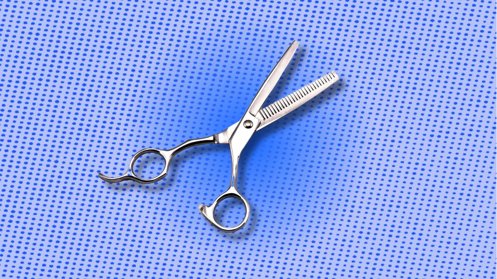 pair of scissors against a blue dot pattern background