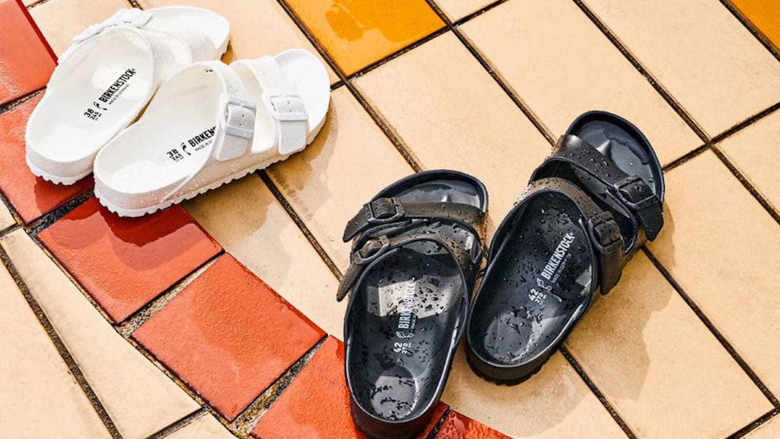 a pair of white and black birkenstock eva arizona sandals sitting by a pool