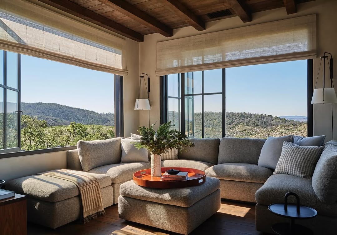 beautiful living room with big windows that look out on mountains in the distance