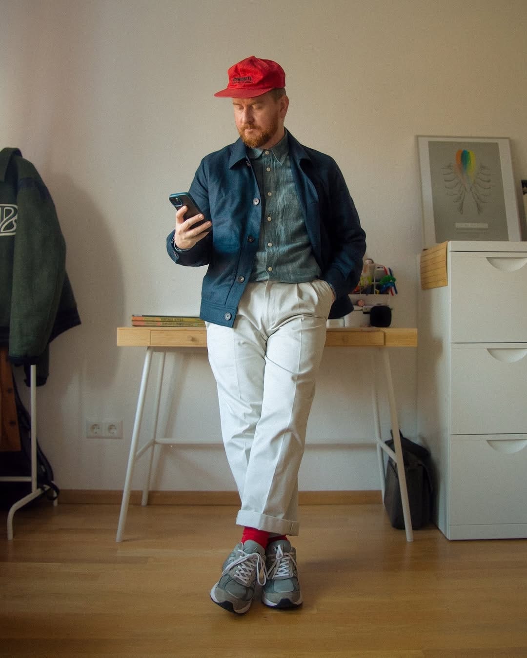 stylish man dressed in a business casual outfit with grey New Balance 99ov6 sneakers and red socks