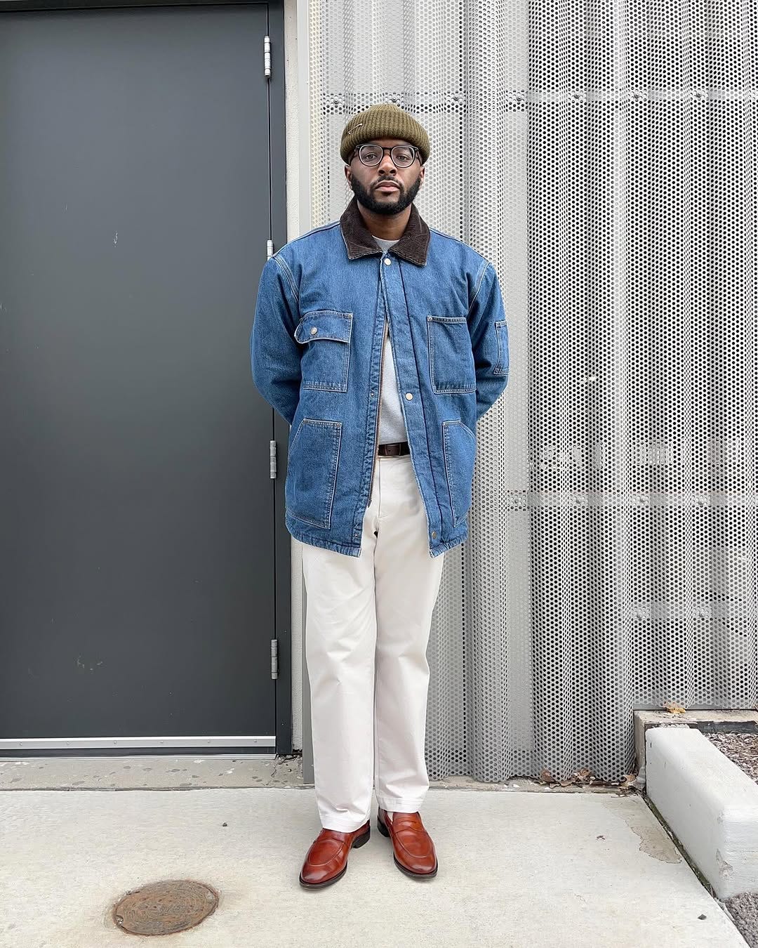 stylish man wearing a denim field jacket with chinos and brown shoes