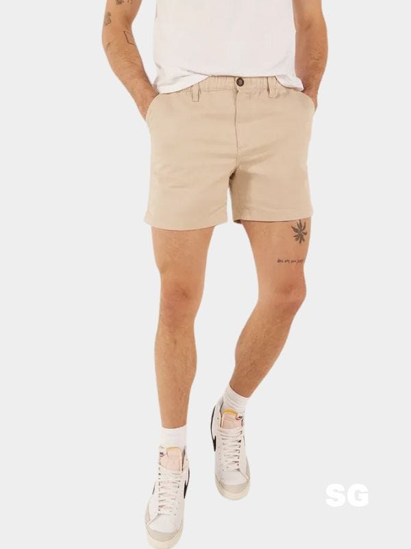 man from the waist down wearing tan shorts and Nike sneakers