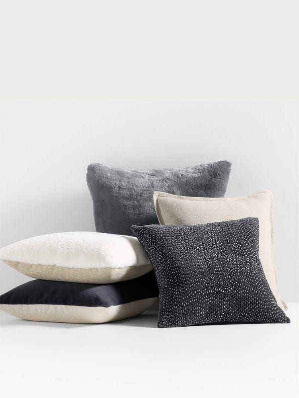 pile of throw pillows in navy and creams