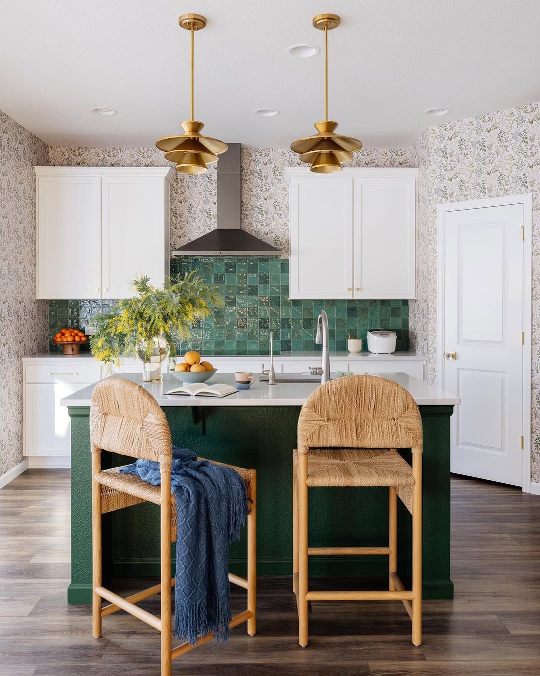 kitchen with a small island and two chairs in front of a stove with a green backsplash