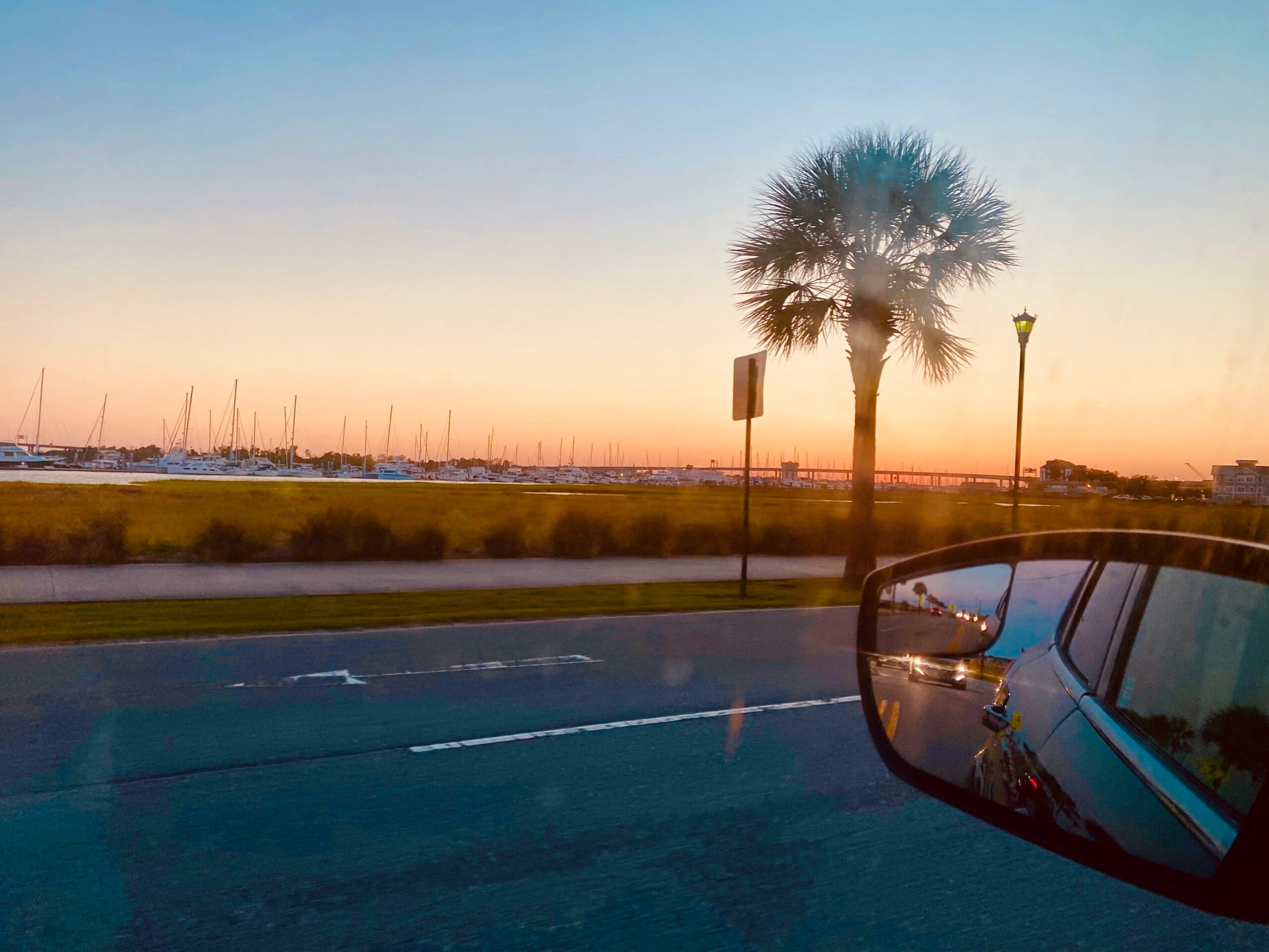 view of the beach at sunset from a car window