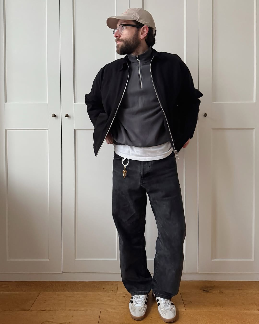 stylish man wearing Adidas Samba sneakers with black jeans and a black zip jacket