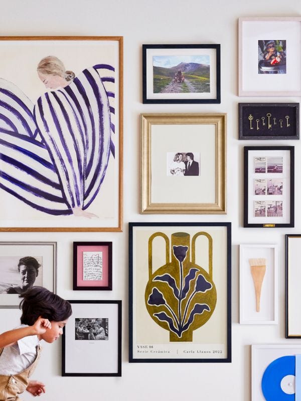 wall full of art in various sizes and color frames