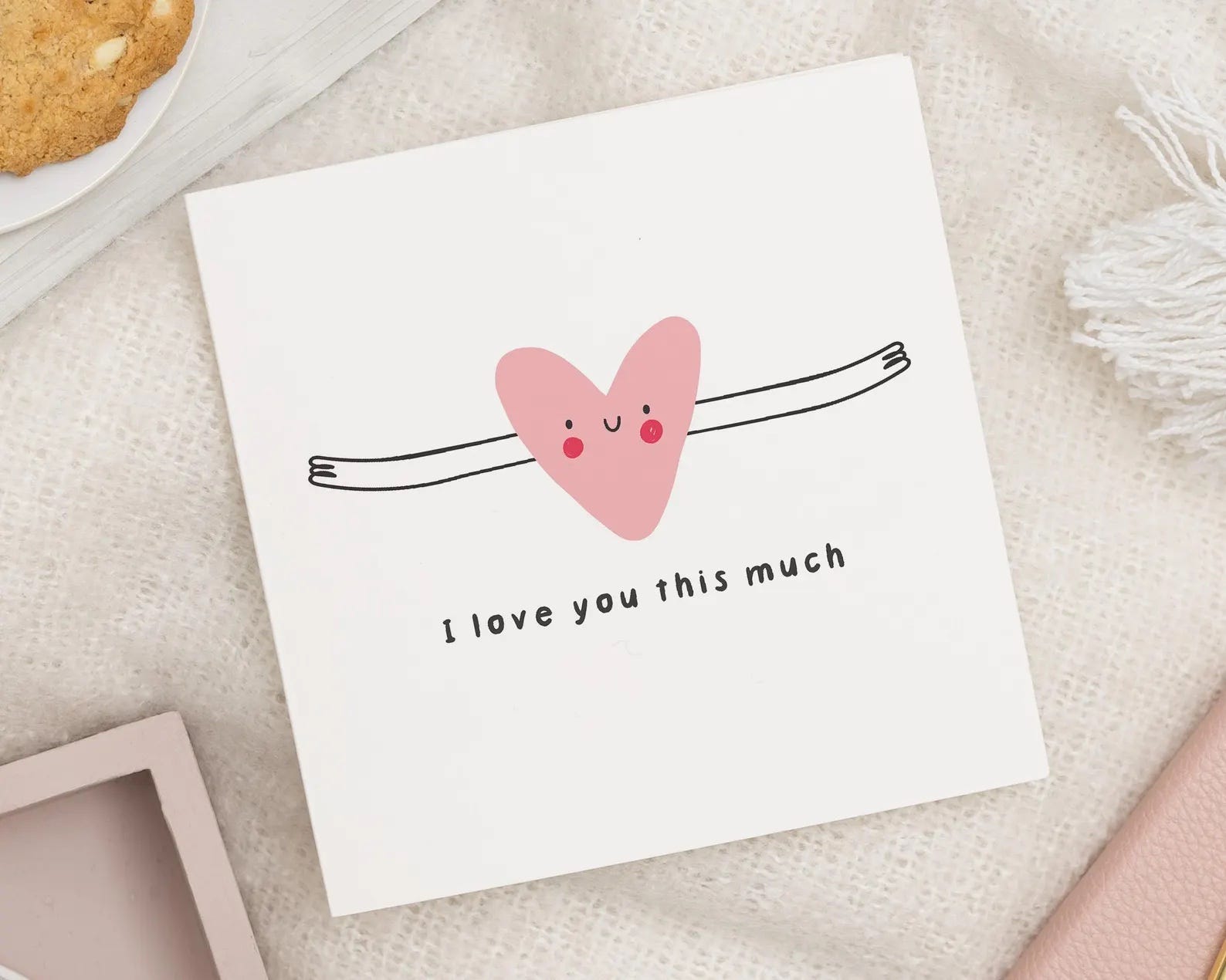 greeting card with a drawing of a heart with outstretched arms. text reads: i love you this much
