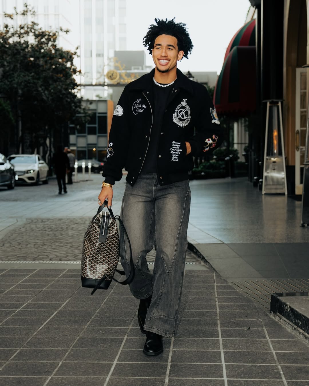 nba player jared mccain wearing a black leather jacket and jeans