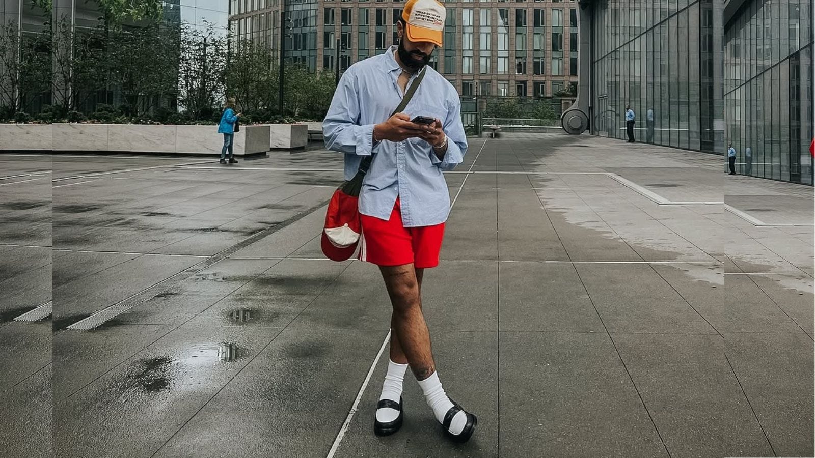 stylish man wearing a blue oxford shirt with red shorts and two-tone loafers
