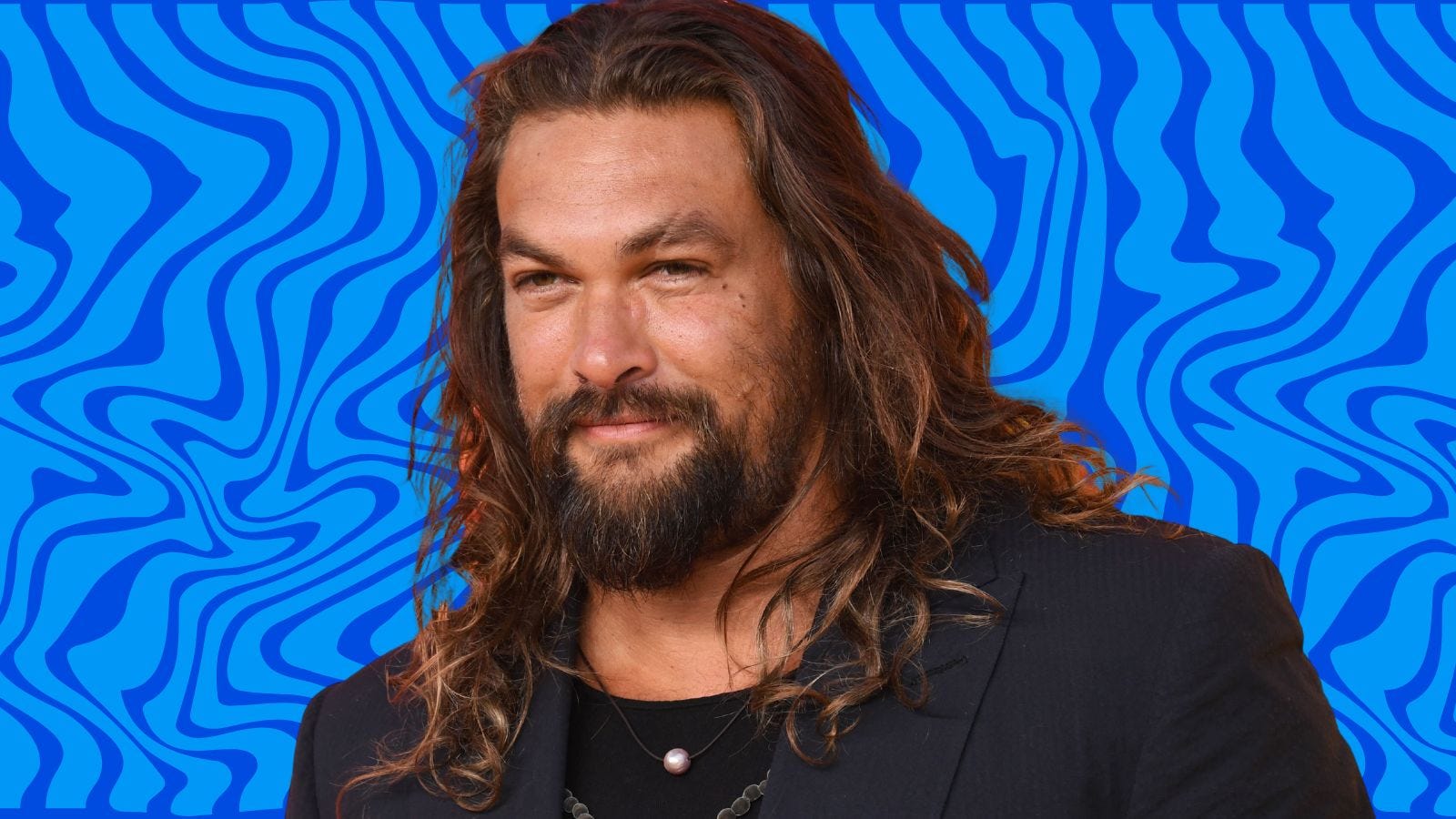 actor Jason Momoa in front of a blue wavy background