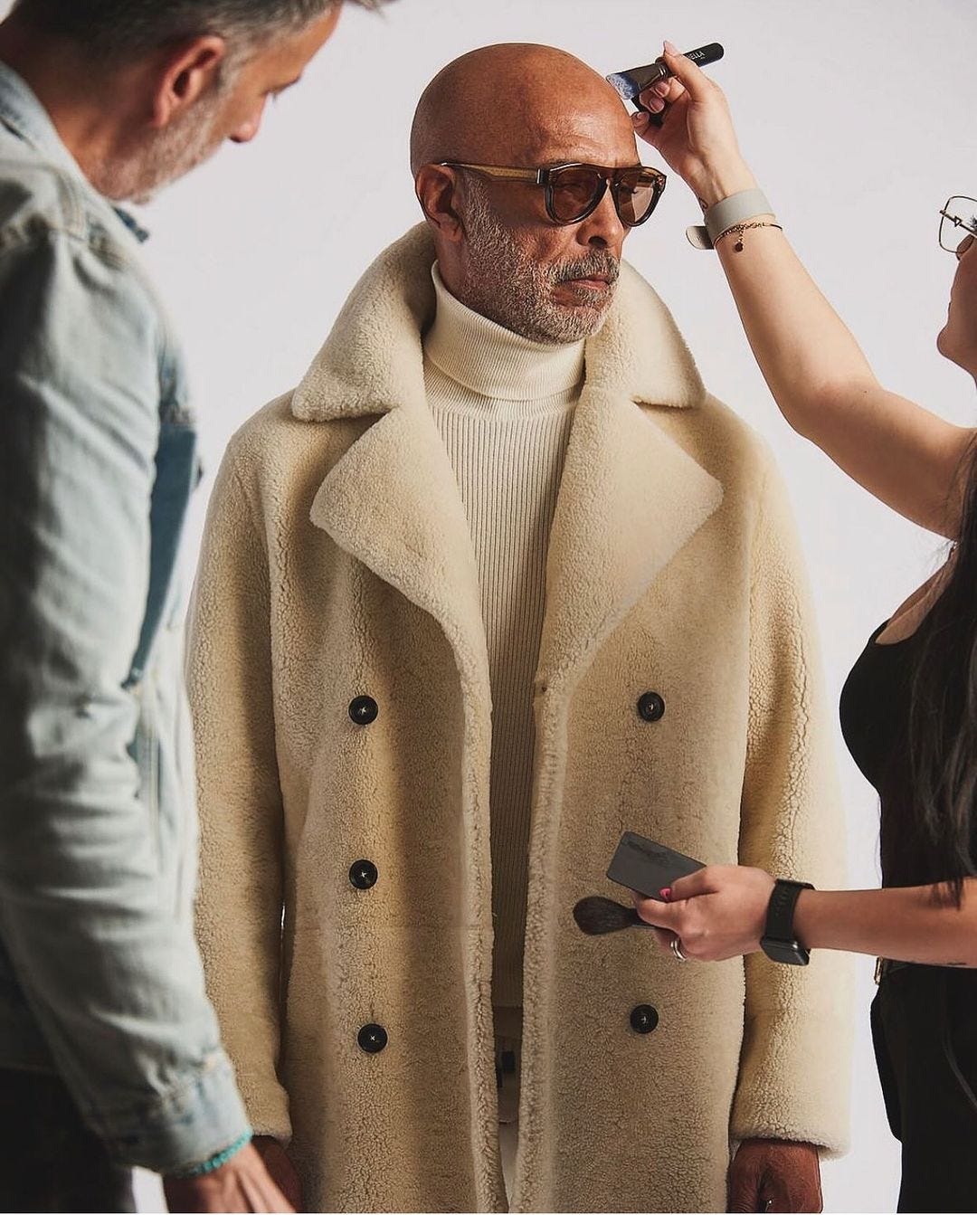 image of an older male model getting touched up on set, featured in an article on style for men over fifty