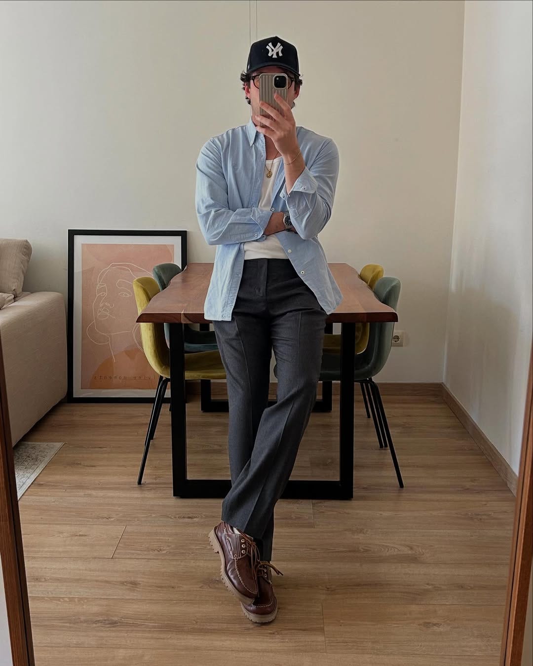 stylish man wearing a blue oxford shirt, white undershirt, charcoal trousers and lug sole boat shoes