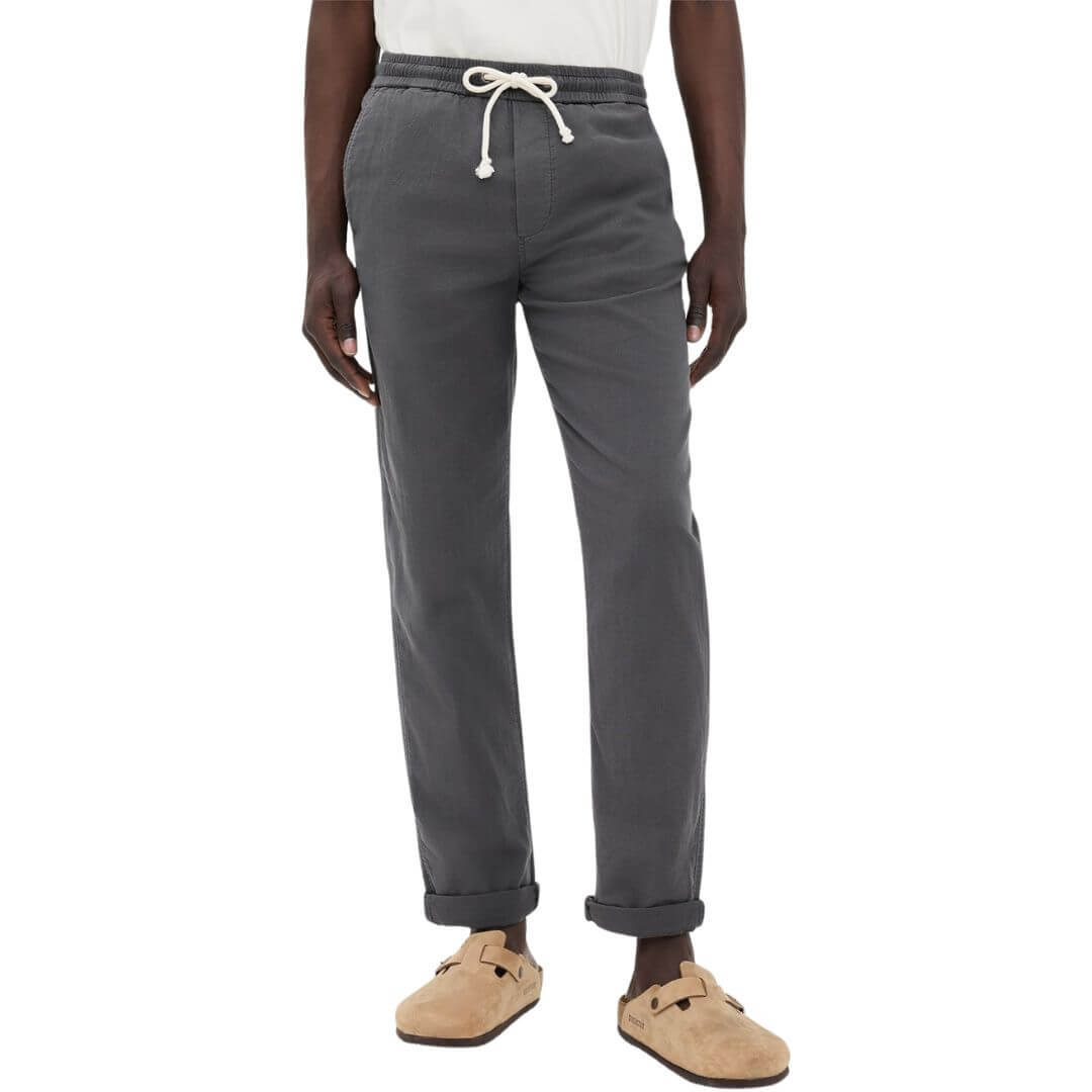 man from the waist down wearing dark drawstring pants with light-colored clogs