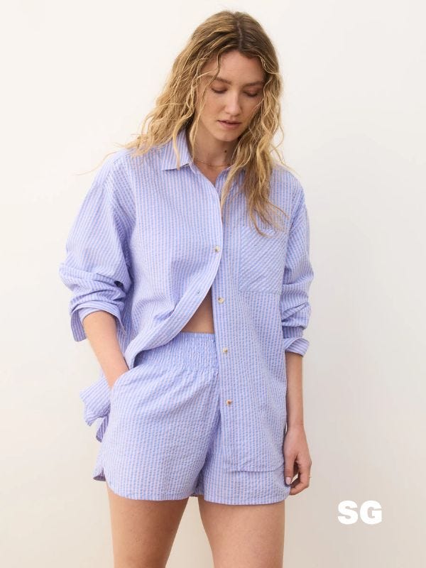 woman wearing a matching oversized seersucker button-down shirt and shorts