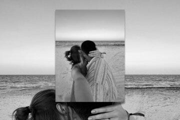 black and white photo of a couple kissing on the beach