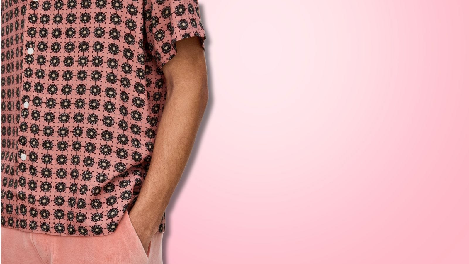 close-up of a man wearing a pink patterned camp shirt with pink terry cloth shorts