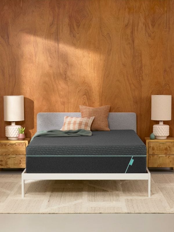 grey mattress on a white bedframe against a wooden wall