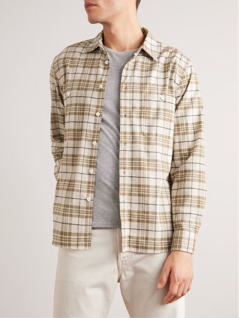 close-up of a man wearing a tan and cream-colored flannel plaid shirt