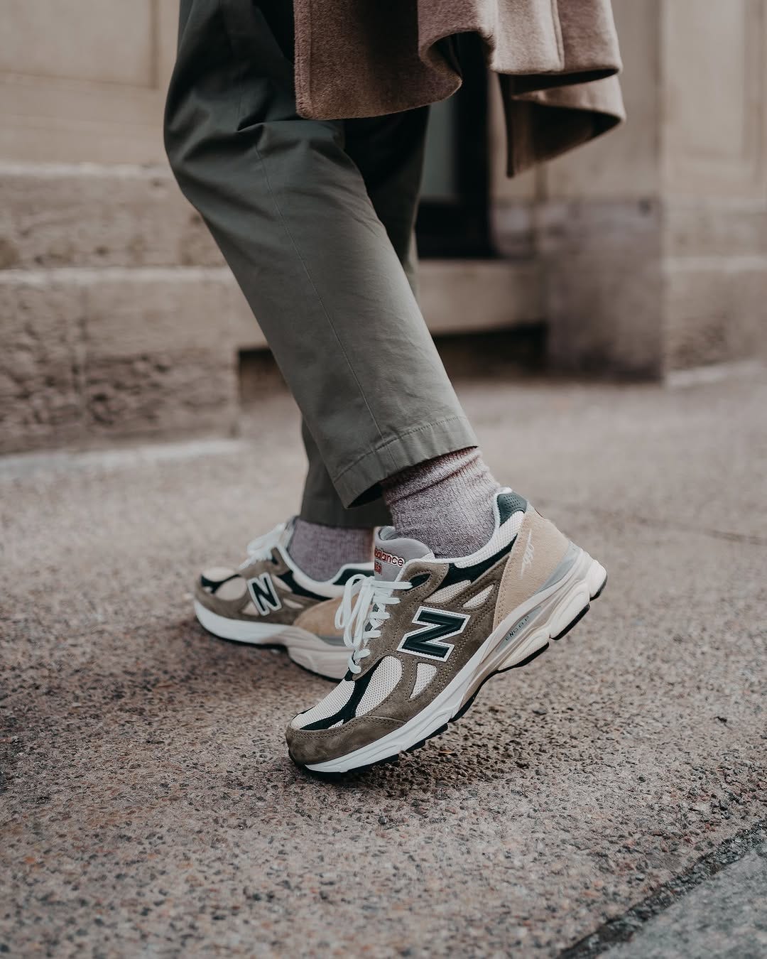 close up of man wearing olive green chinos with tan socks and New Balance sneakers