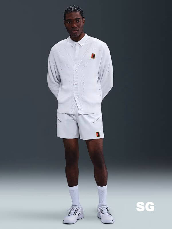 stylish man wearing a nike tennis outfit featuring a white cardigan and shorts