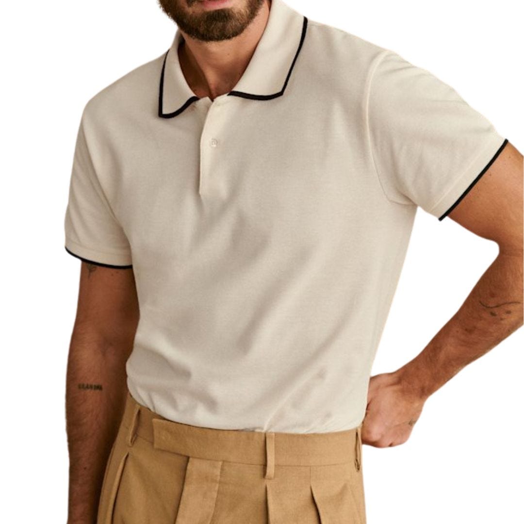man wearing a cream-colored knit polo with black detailing at the neck and arms