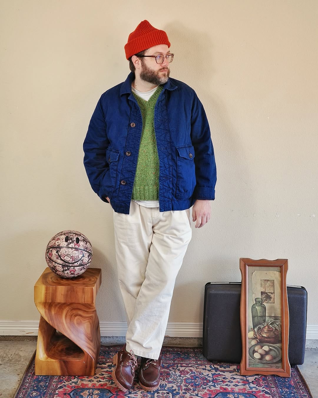 Casual Men's Spring Outfit featuring a blue chore coat, green sweater, stone chinos and brown boat shoes