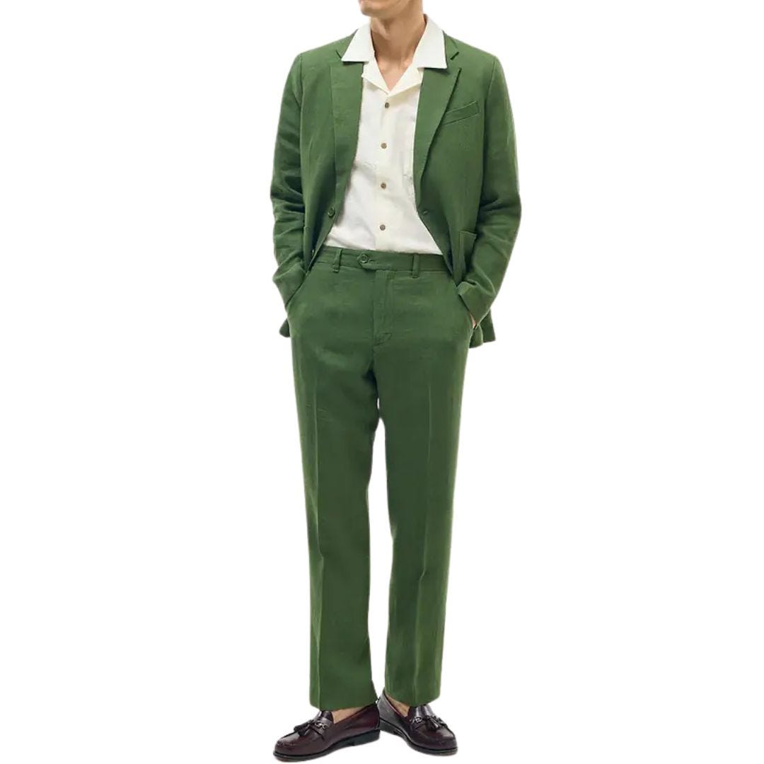 man from the neck down wearing a green linen suit with an off-white button-down camp shirt