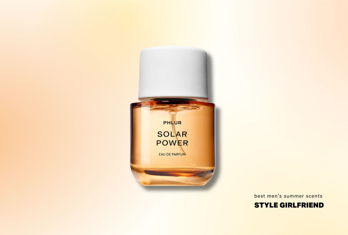 a clear round fragrance bottle with orange liquid and a round white cap