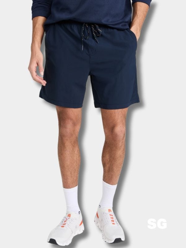 man wearing navy hybrid shorts and white sneakers