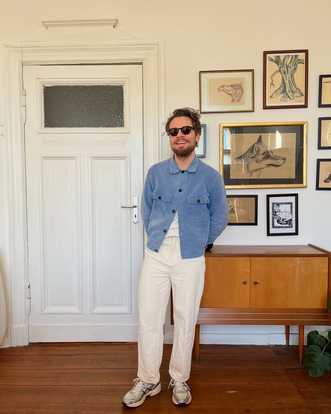 image of a stylish man wearing a blue trucker jacket over a white t-shirt with stone-colored chinos in a roundup of Casual Men's Spring Outfits on stylegirlfriend.com