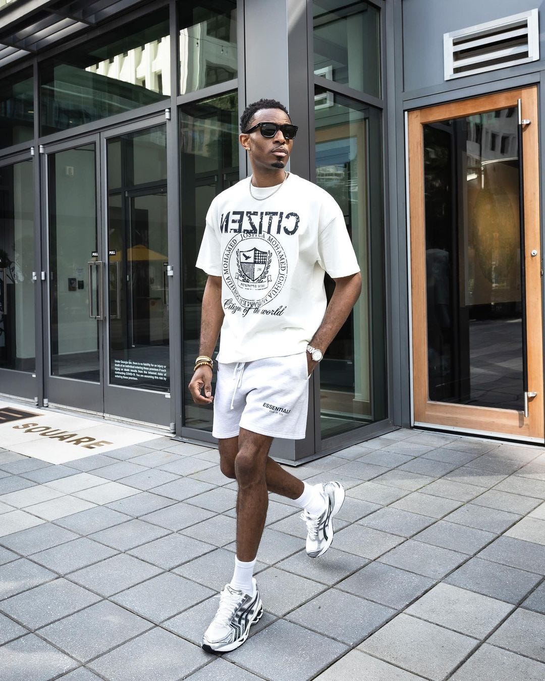 man in white t-shirt and shorts with tall socks and sporty sneakers