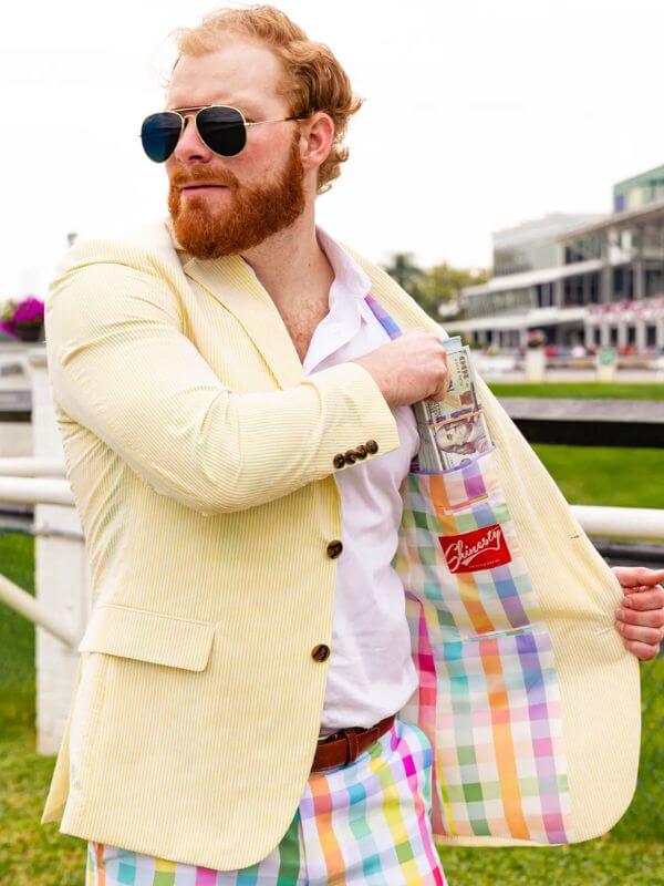 man wearing a butter yellow seersucker blazer with bright plaid pants