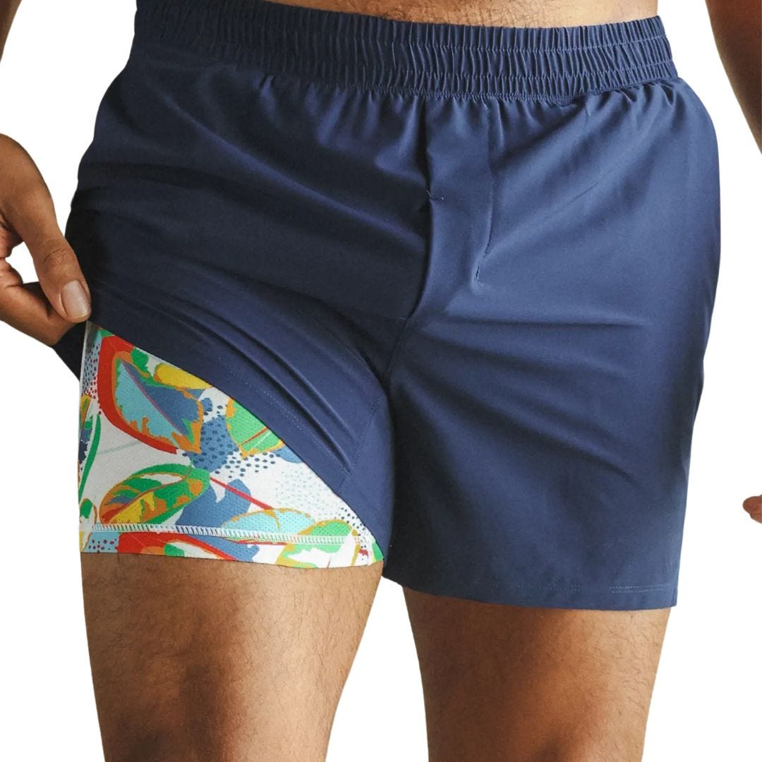 close-up of a man wearing navy lined shorts with a brightly patterned lining