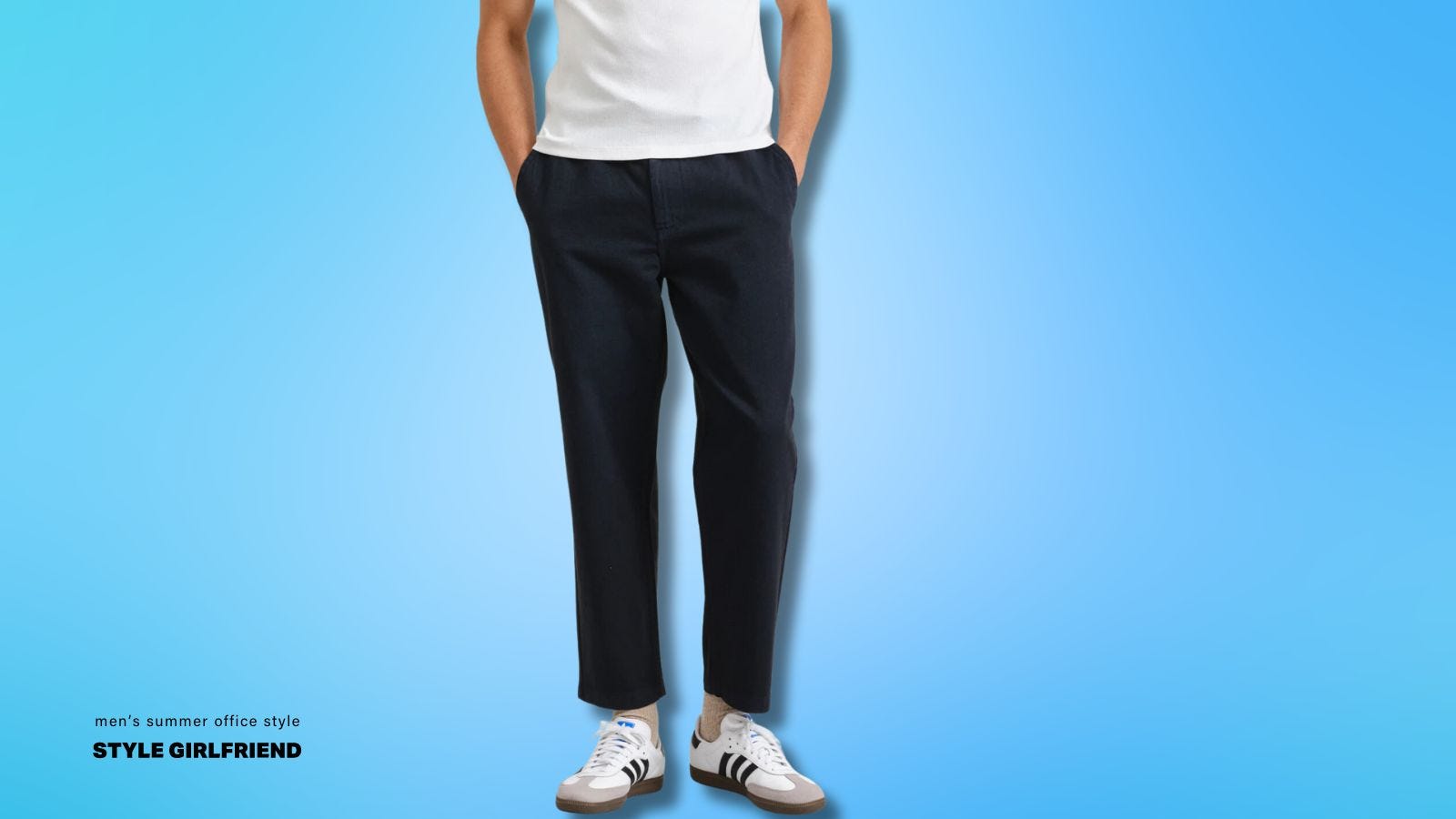 torso and legs of a man wearing a white t-shirt and navy pants with white Adidas Sambas. text on-screen reads: mens summer office style