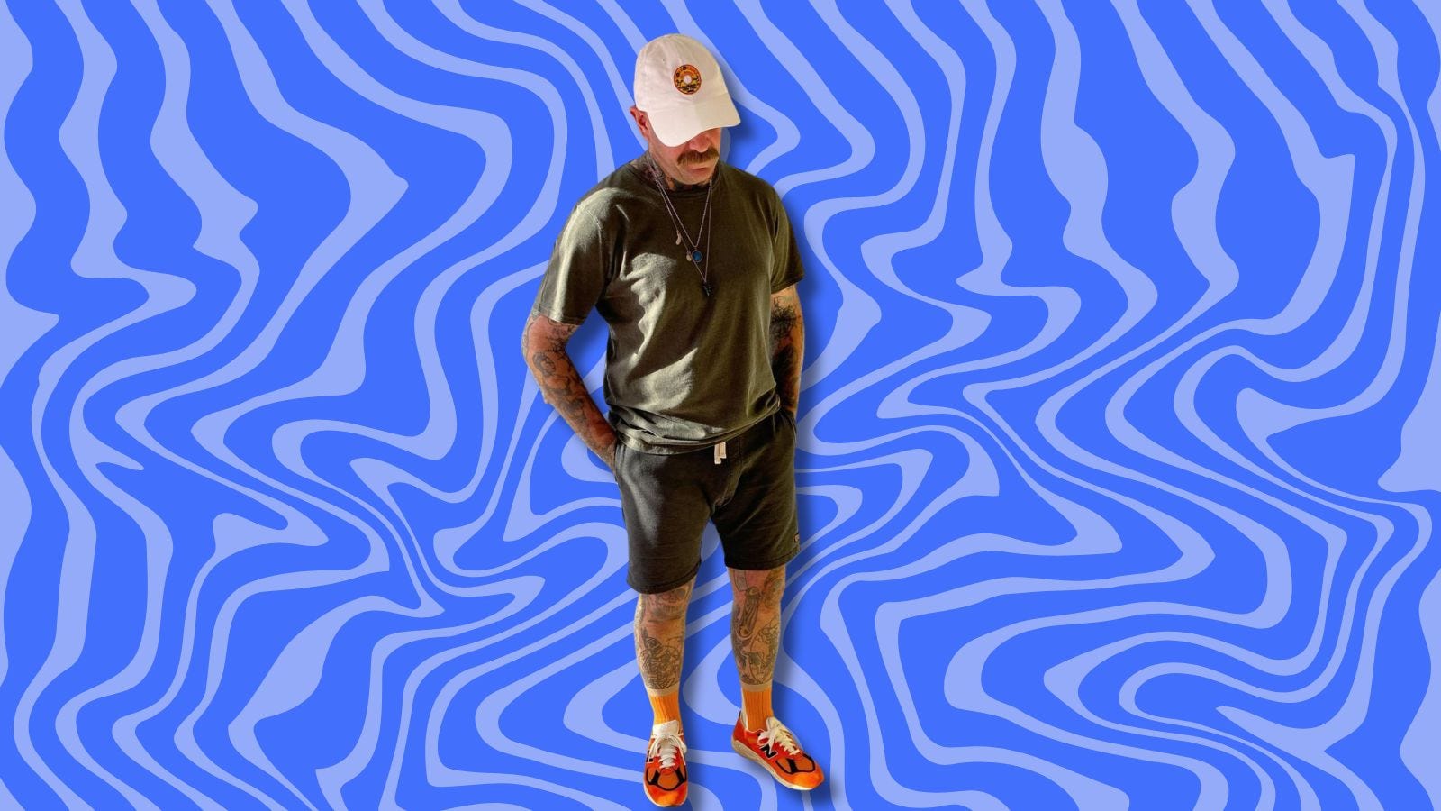 man wearing a t-shirt, shorts, tall orange socks and orange sneakers, set against a wavy blue background