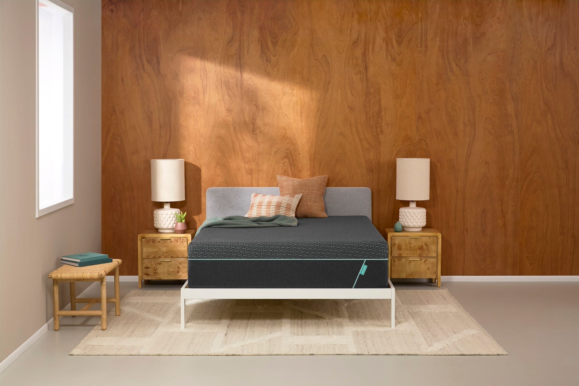 grey mattress on a white bedframe in a bedroom with wooden walls
