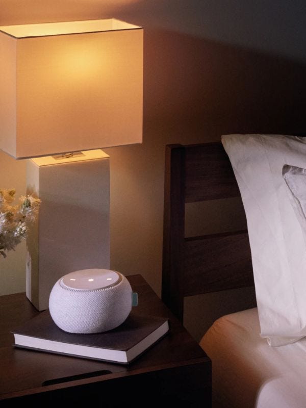 white noise machine sitting on a bedside table