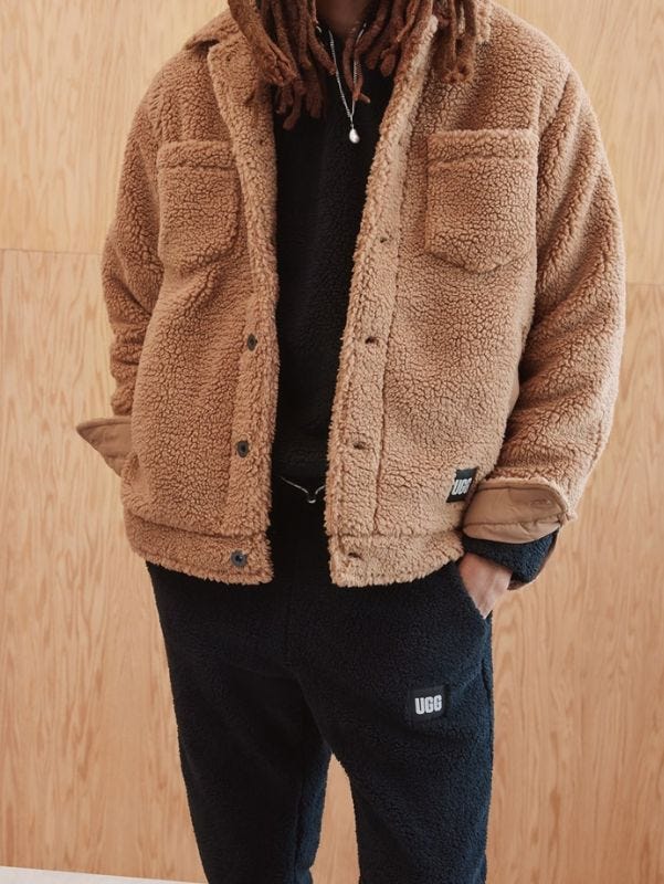 close-up of a man wearing a sherpa trucker jacket with black sweats underneath